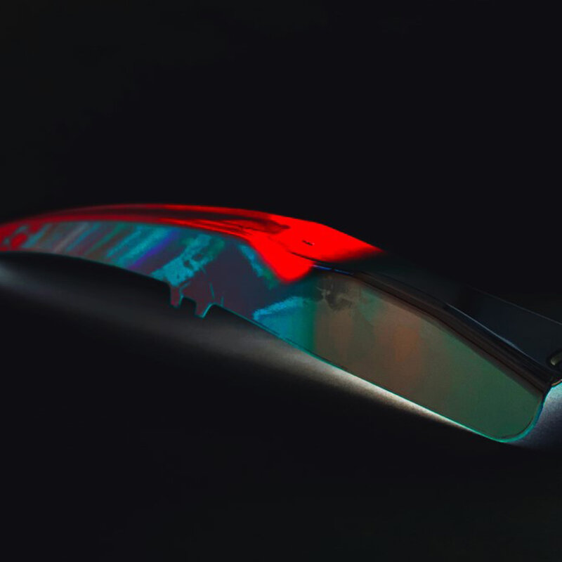 Ein SoftZone (Tailored Tempering) Bauteil fotografiert auf einem dunkelen Hintergrund; die verschiedenen Bauteilbereiche bzw. Bauteileigenschaften sind in unterschiedlichen Farben und leuchtend dargestellt
