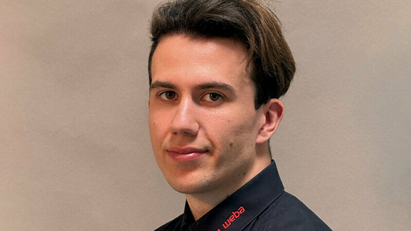 Michal Urbuś, IT-Techniker Porträtfoto von Michal Urbuś, IT-Techniker bei weba Werkzeugbau, in schwarzem Hemd mit rotem weba-Logo vor neutralem Hintergrund.