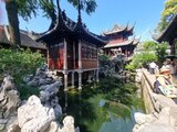 Traditionelle chinesische Pavillons mit kunstvoll geschnitzten Dächern und einem Teich im Vordergrund – Aufnahme aus Jan Wengryns Besuch im Yu-Garten in Shanghai.