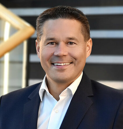 weba Werkzeugbau - Hannes Feuerhuber Porträt des Geschäftsführers von weba Werkzeugbau, aufgenommen auf einer Glasstiege. Er steht souverän und selbstbewusst, mit einem leichten Lächeln, was Führungsstärke und Professionalität ausstrahlt. Die moderne Glasstiege verleiht dem Bild eine elegante und zeitgenössische Atmosphäre, die die fortschrittliche Ausrichtung des Unternehmens unterstreicht.