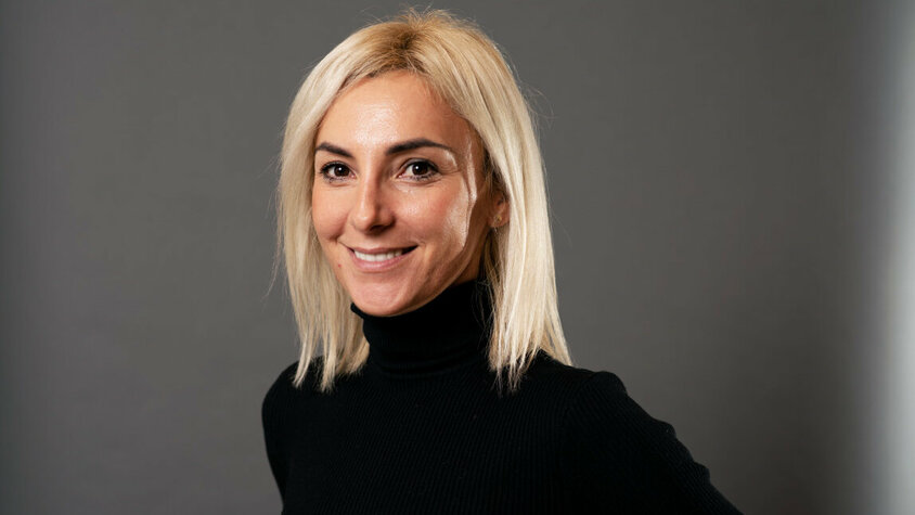 weba Werkzeugbau - Ivana Vujica Porträt von Ivana Vujica, strategische Einkäuferin bei weba, vor einem grauen Hintergrund.