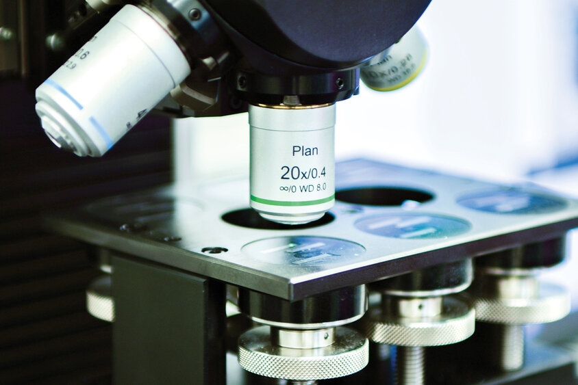 Nahaufnahme eines Prüfgeräts für metallographische Analysen, das detailliert das komplexe und präzise Instrumentarium zeigt. Das Gerät wird verwendet, um die mikroskopische Struktur und Eigenschaften von Metallen zu untersuchen.