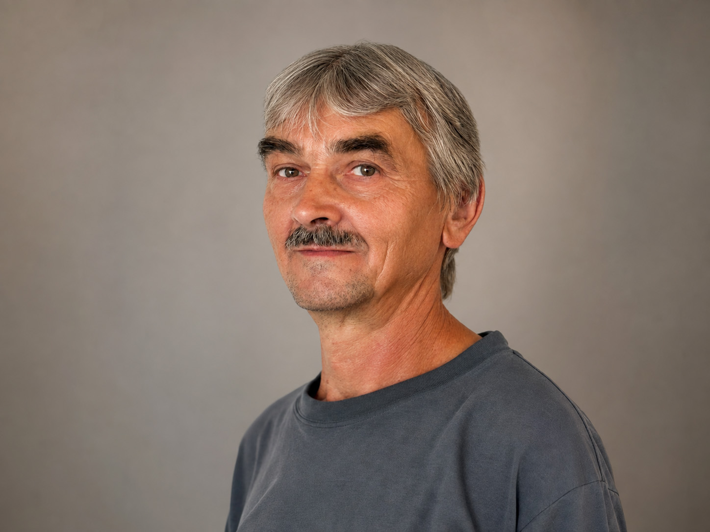 Profesionální portrét Františka Krumpolce před decentním šedým studiovým pozadím.
