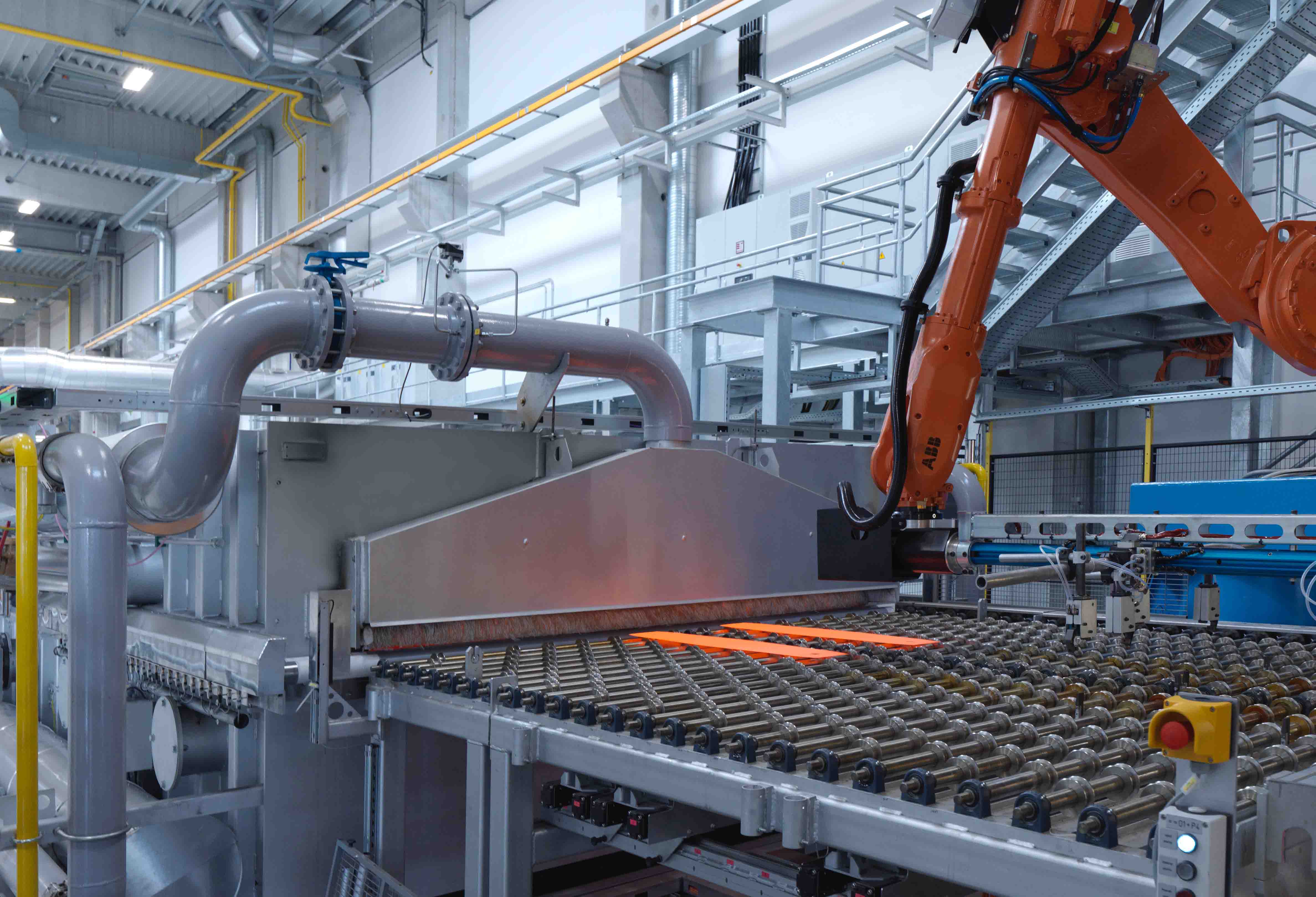 Automatisierte Warmumformungsanlage mit Roboterhandling und glühendem Stahlblech zur Herstellung hochfester Leichtbauteile.